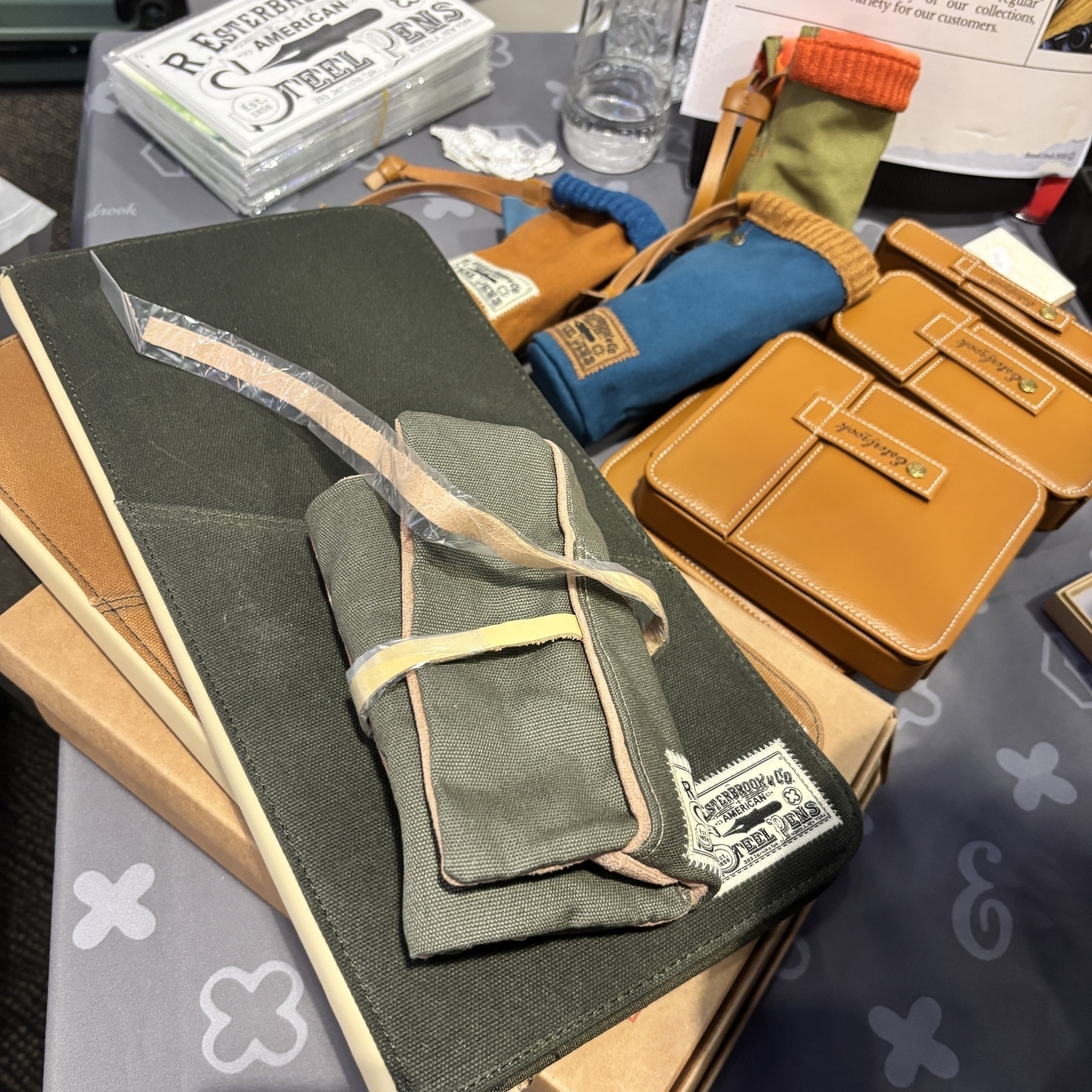 Op tafel liggen verschillende notitieboeken, pouches en lederen accessoires.